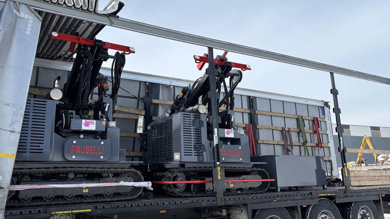 Tracked excavator driving a rammed C-profile post on a Nordic solar site