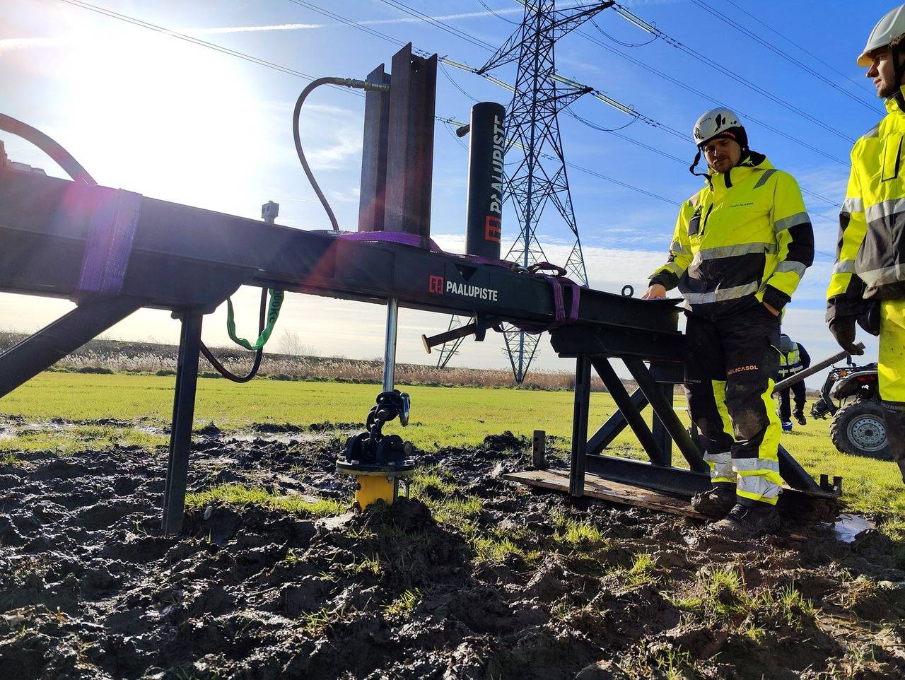 Helicasol crew on site at a Nordic solar project — installing helical pile under transmission lines in winter