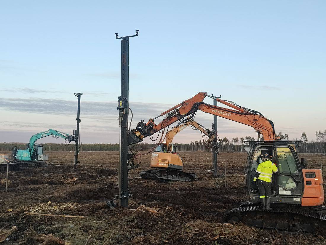 Helicasol crew running multiple GPS-guided drilling rigs in parallel on a Nordic solar site at dusk